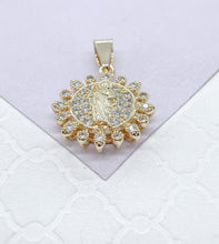 Load image into Gallery viewer, May include: Gold pendant with a clear crystal halo surrounding a religious figure. The pendant has a loop at the top for attaching to a chain.
